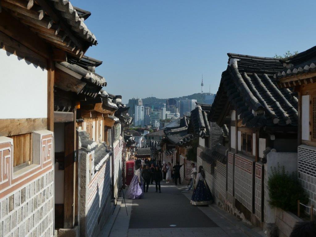 Traditional homes contrast with modern skyscapers at Bukchon Hanok Village, Seoul